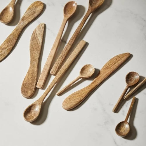 a few items of wooden cutlery laid in a slight jumble on a marble table