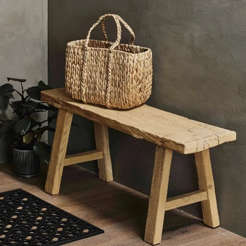 small elm wood bench in a hall way with a wicker basket on waiting to head out shopping