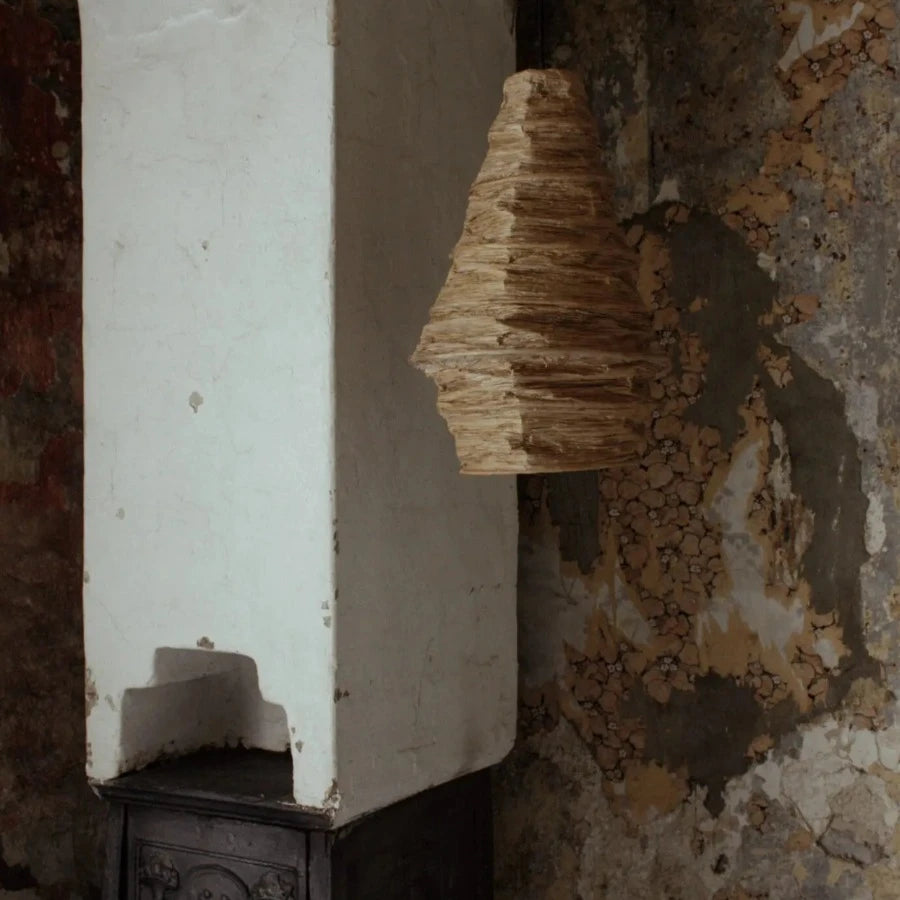 an almost wasp nest looking ceiling lamp shade hangs in a corner of an old house. the fabric giving the shape life. nordic style from swedish design house olsson and jensen