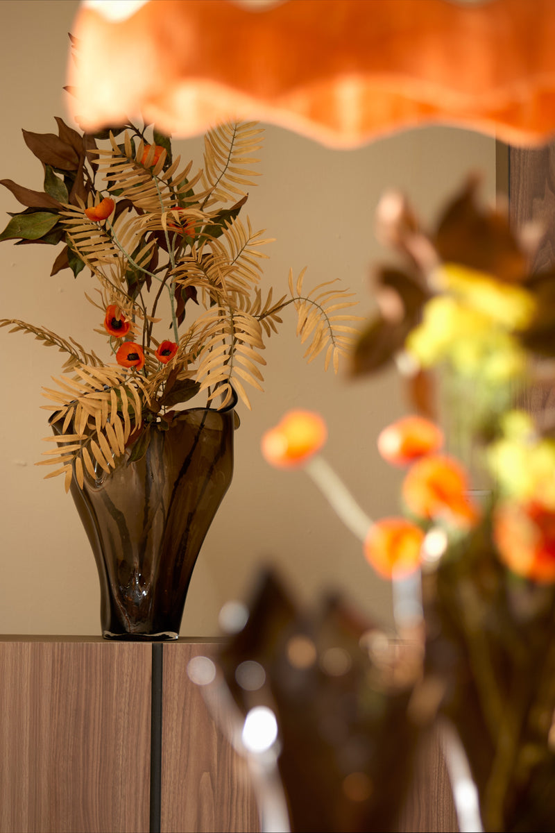 Aiora vase in dark brown holding decorative branches on wooden cabinet