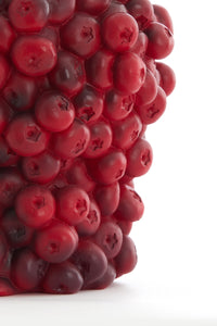 detailed view of red berry-textured vase surface showing rich shading
