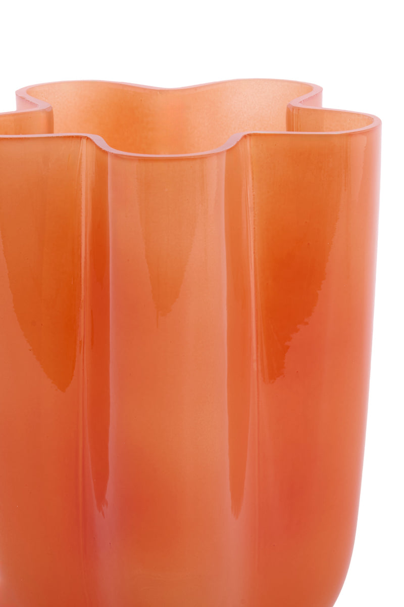 detail of orange glass vase showing translucent gradient and wavy form
