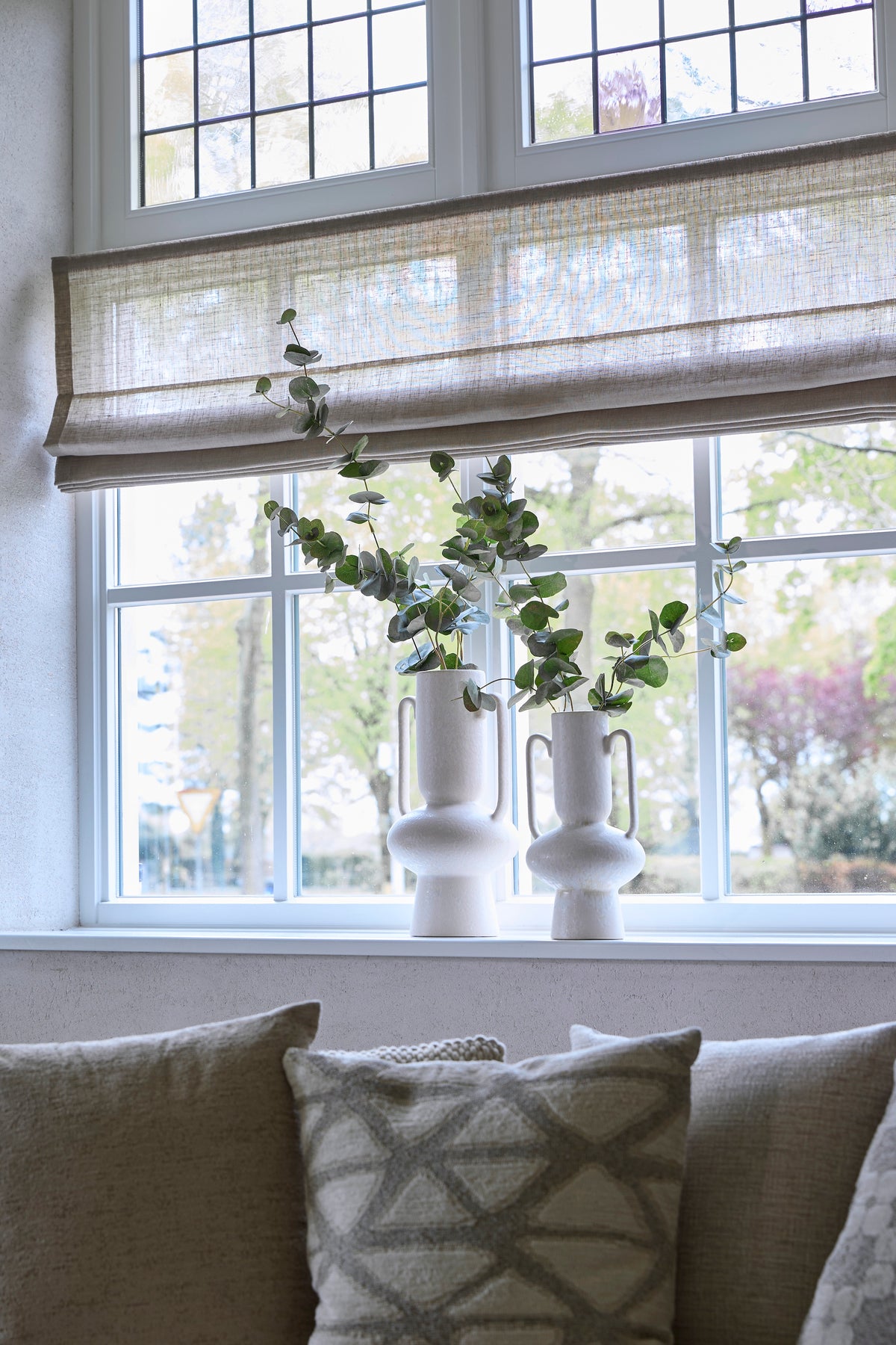 pair of cream sculptural OTARU vases styled on a windowsill with eucalyptus stems
