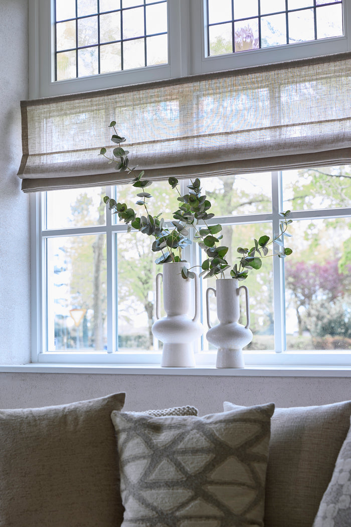 pair of cream sculptural OTARU vases styled on a windowsill with eucalyptus stems
