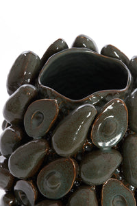close-up of sculptural avocado shapes on glossy brown-green ceramic vase