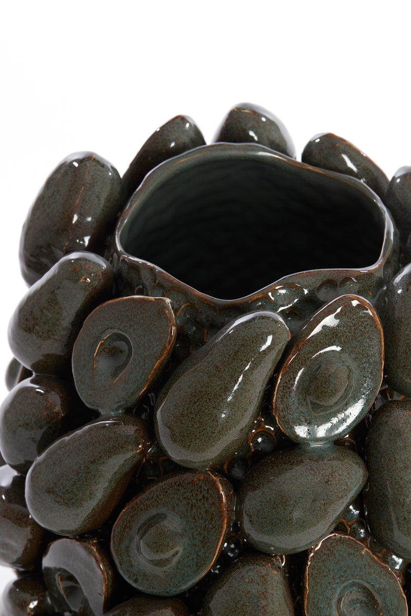 close-up of sculptural avocado shapes on glossy brown-green ceramic vase