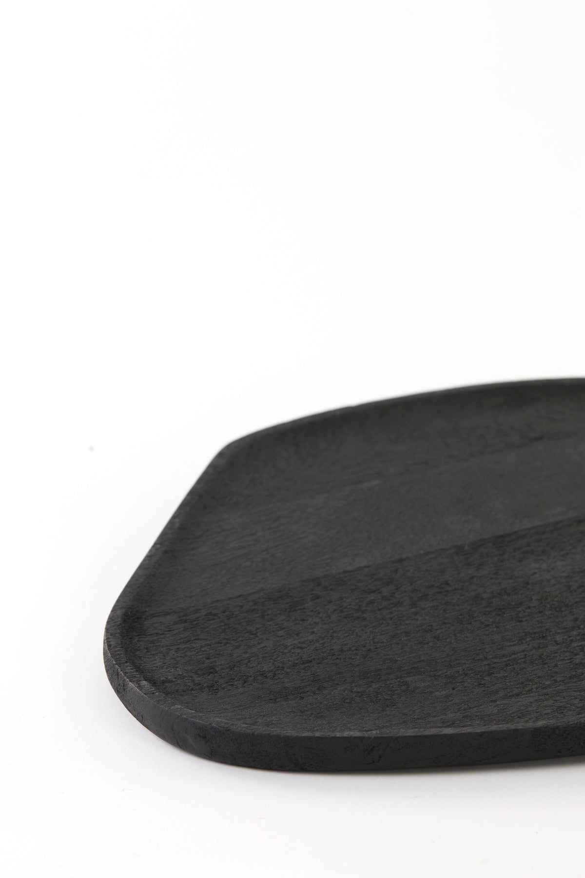close-up of matte black acacia wood dish showing grain and soft rim
