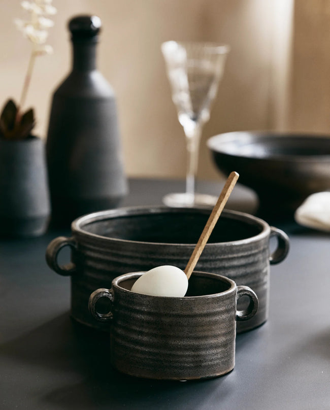 black ceramic serving bowls with small handles on the sides
