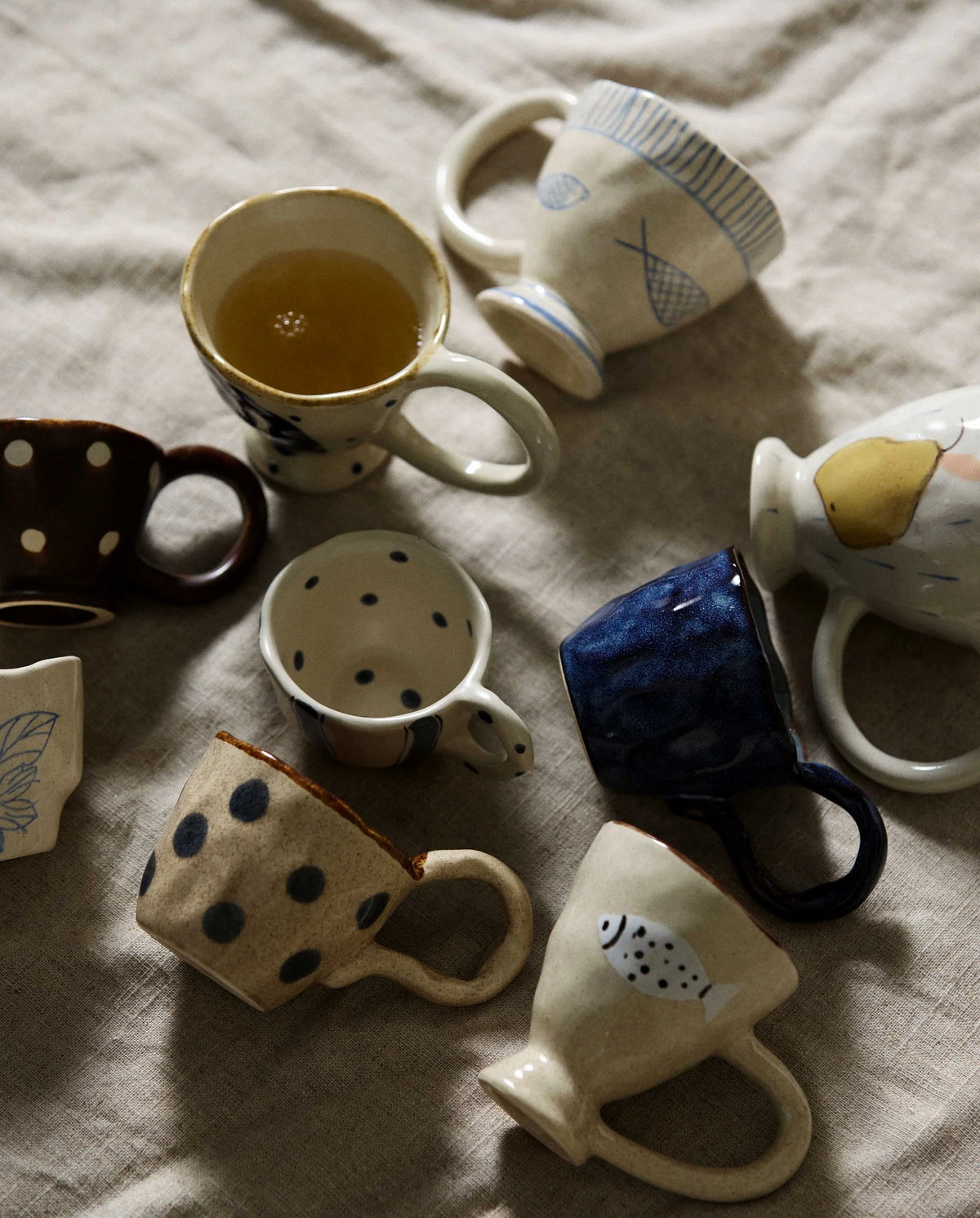 Close-up of the GOGI cup by Nordal's rounded handle with hand-painted blue dots