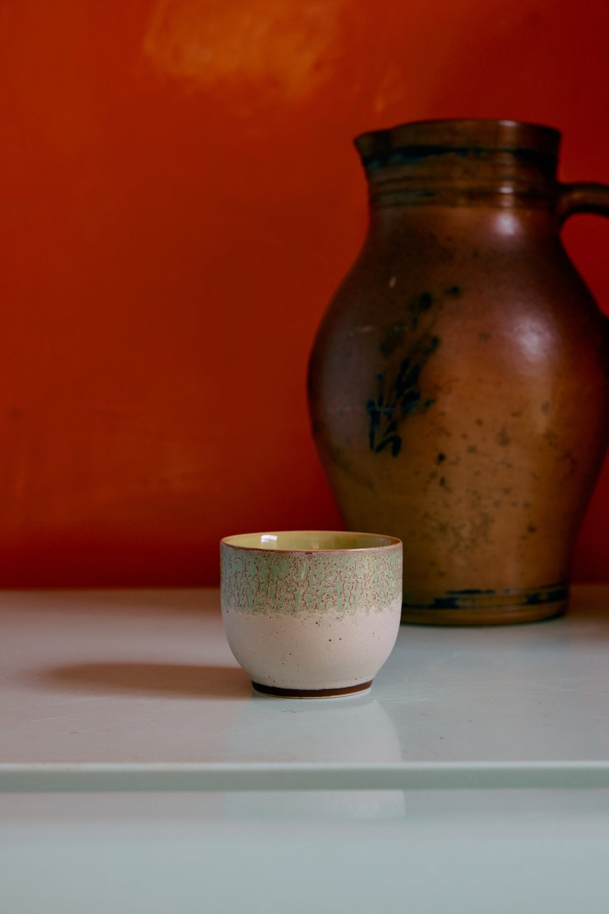 chalk café cup by HKLIVING styled on a shelf with vintage ceramics
