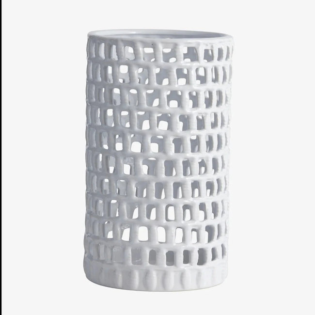 hand made tall cylindrical white ceramic candle holder with small hand cut square holes creting an almost lattice effect from nordal