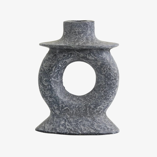 with a stone like rough hewn texture a cnadle holder which is like a donut on a stand and with a candle holding hat in grey white