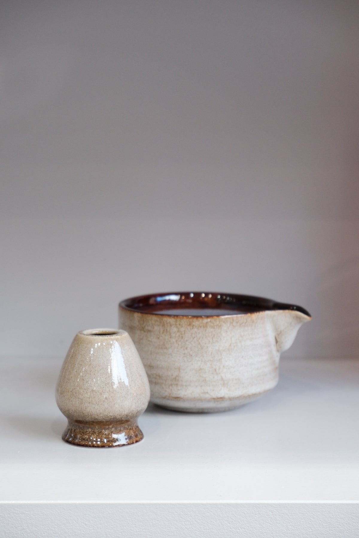 side view of 80s style matcha bowl set showing brown interior glaze and pouring spout
