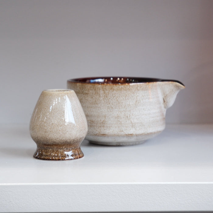 retro ceramic matcha bowl with brown interior and grey brown exterior with matching whisk stand
