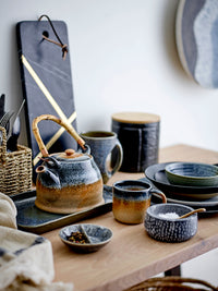 Aura cups in blue and brown displayed with other Nordic ceramics
