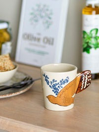 Bloomingville Hezha Cup in Blue styled on a kitchen counter with olive oil and a plate in the background.