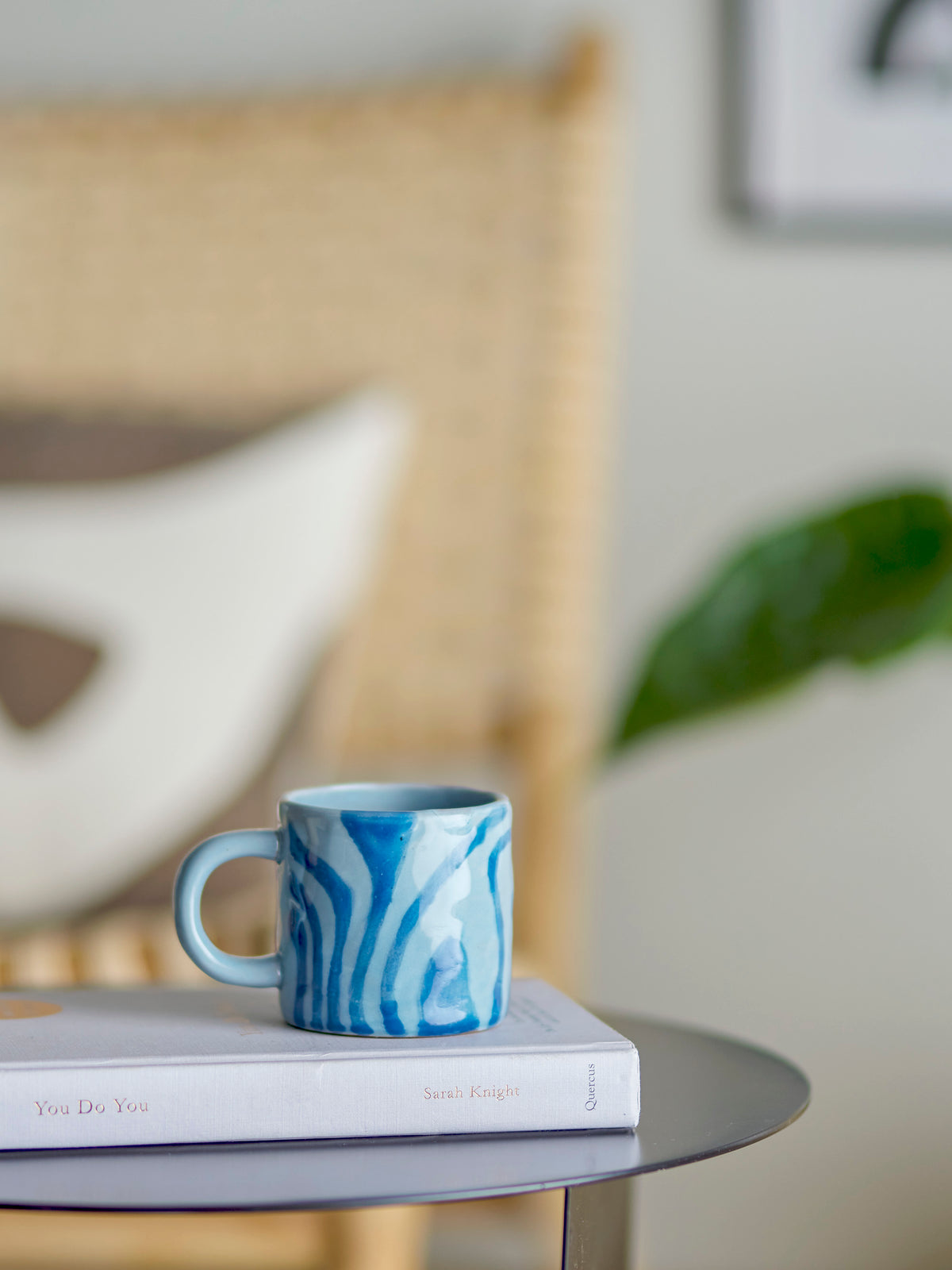 blue bloomingville ninka mug styled on a book in a relaxed living room setting