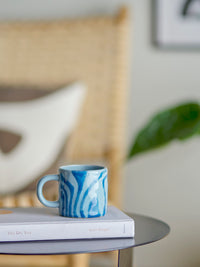 blue bloomingville ninka mug styled on a book in a relaxed living room setting