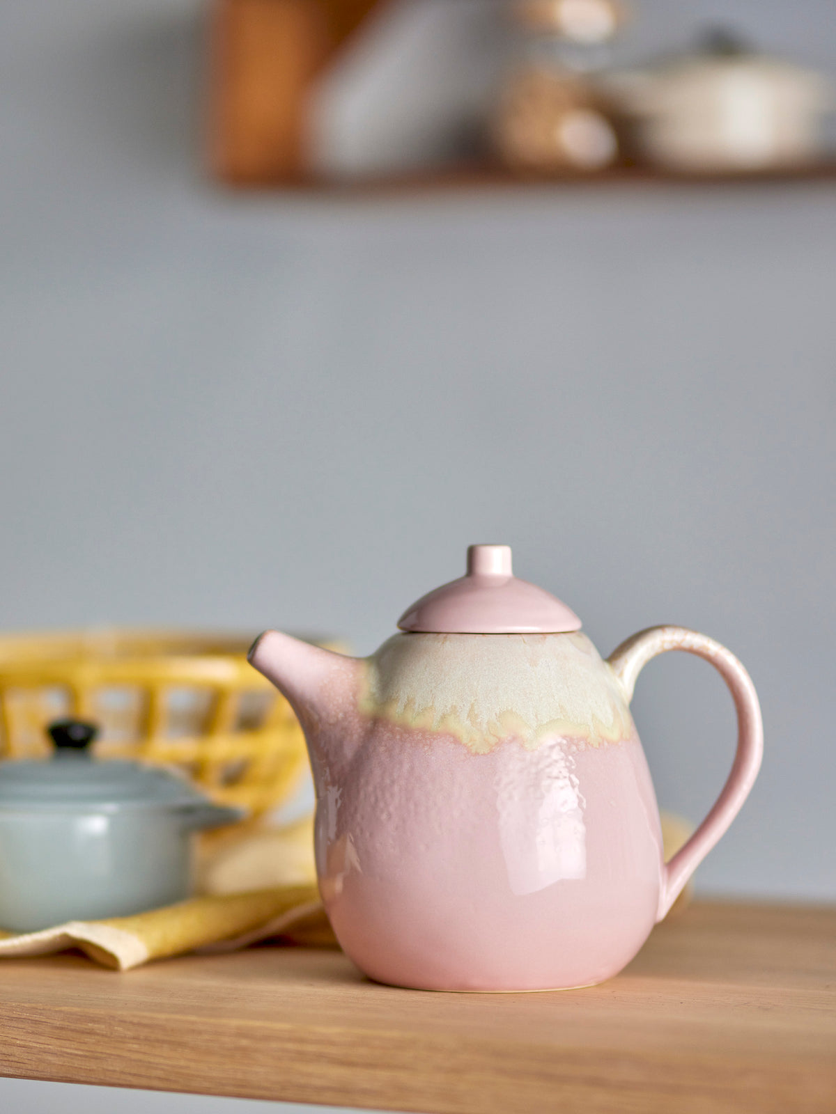 pink and cream ceramic tea pot with high spout and generous size on wooden worktop