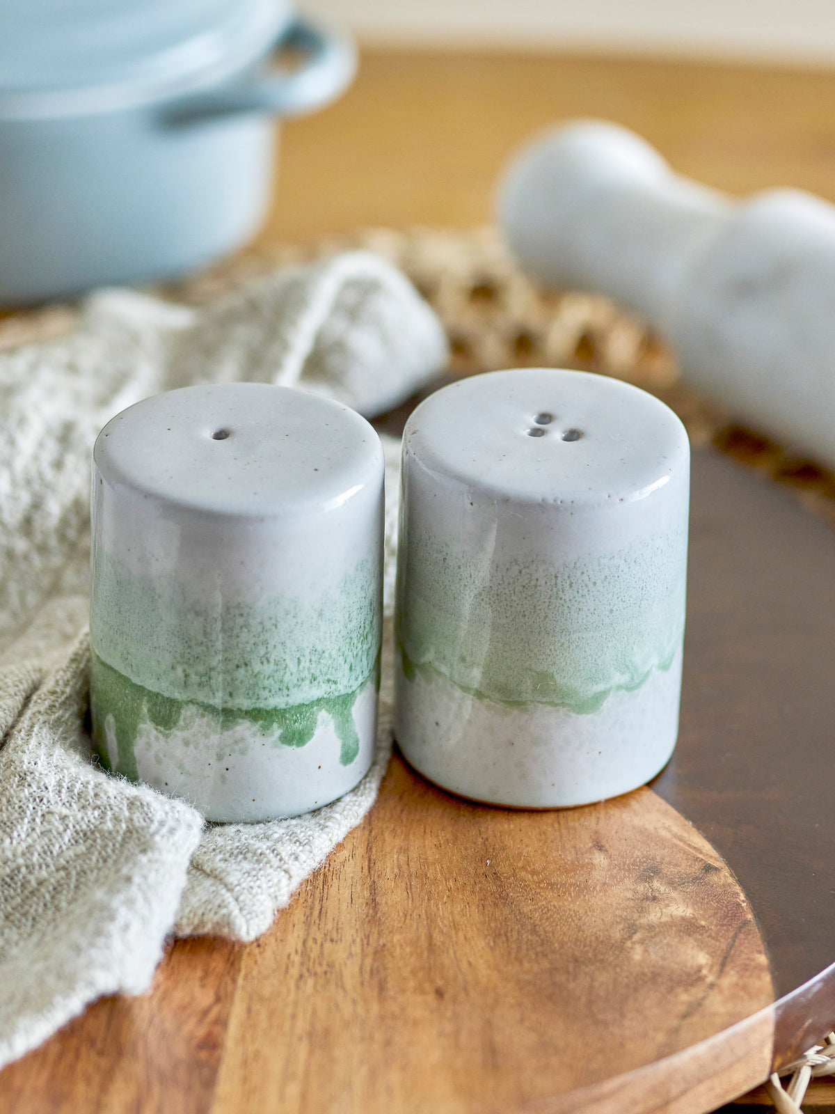 close-up of reactive glaze green stoneware salt and pepper shakers
