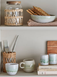 paula green salt and pepper shakers styled on open shelf with matching tableware
