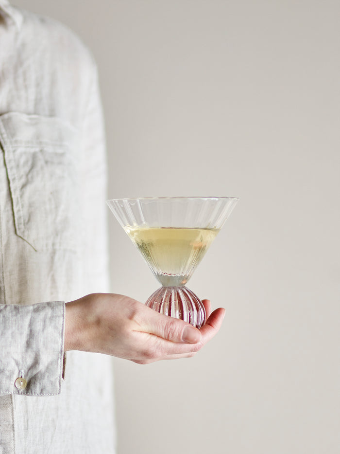 Taurin cocktail glass with round base, held in hand and filled with a cocktail, 300ml
