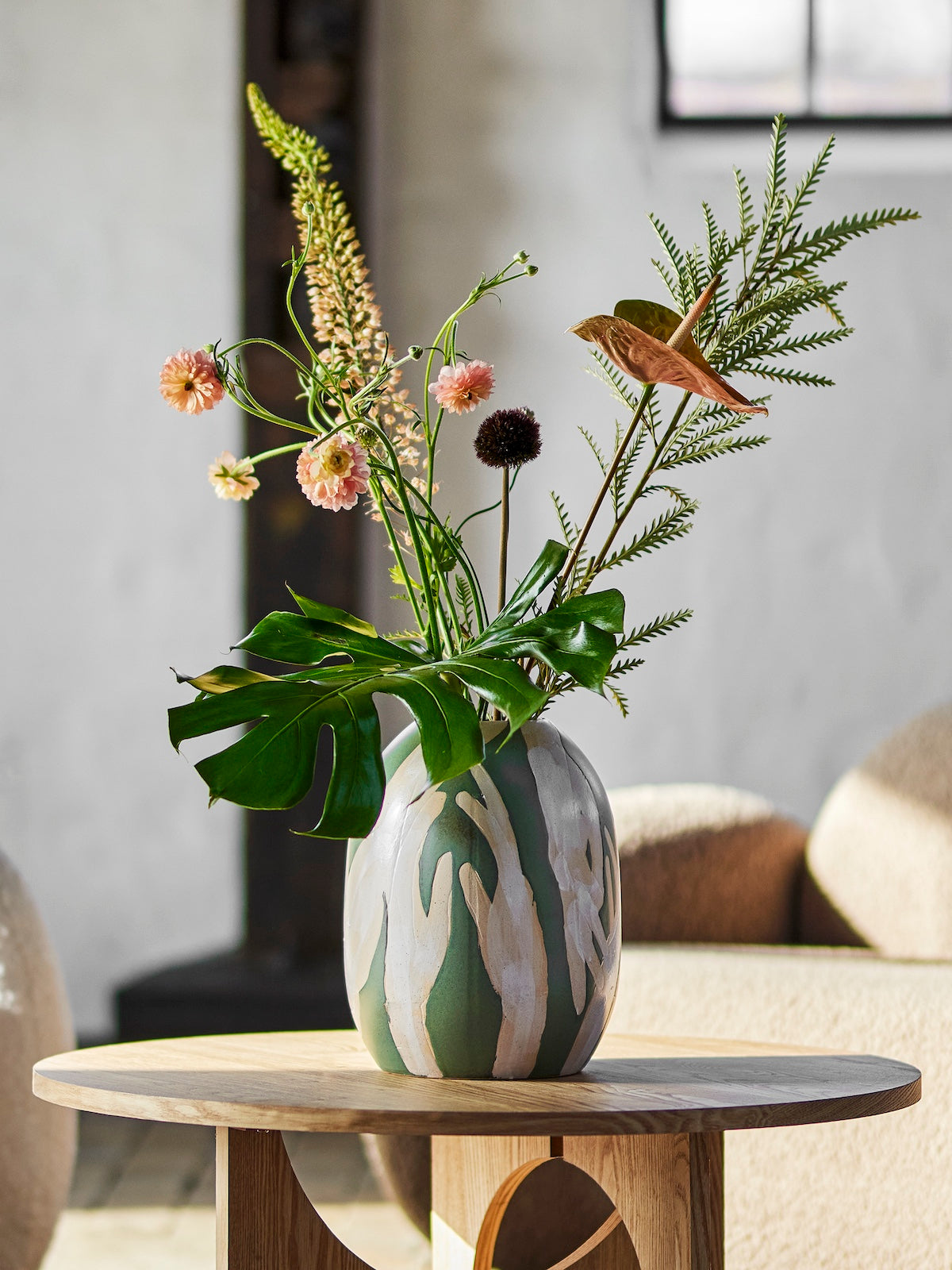 Decorative vase with flowers on a wooden table in a room setting