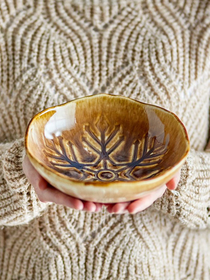 Acco bowl large brown stoneware with snowflake motif, held in hand
