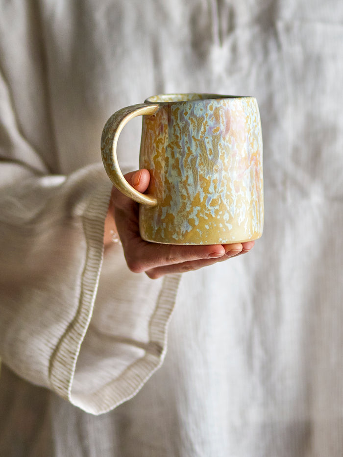 Yori mug by Bloomingville held in hand, showing colourful reactive glaze
