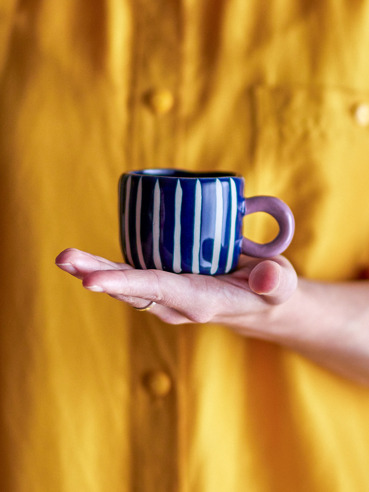 hand holding blue striped bloomingville nini cup showing hand-painted details