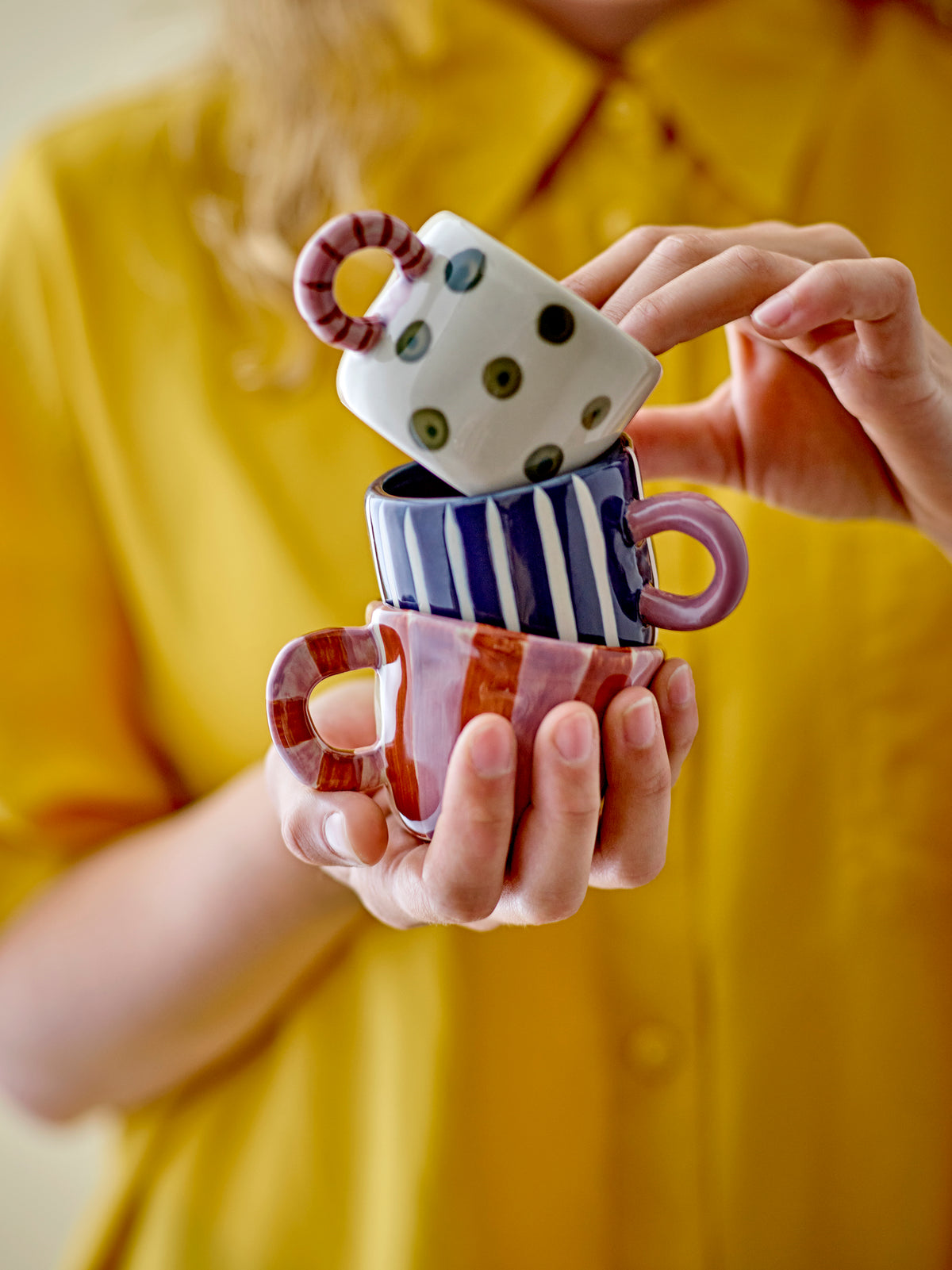 person stacking colourful bloomingville mini mugs including the blue nini cup
