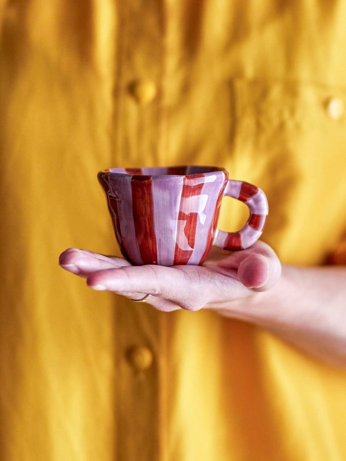 hand presenting the red striped bloomingville nini cup with handcrafted design