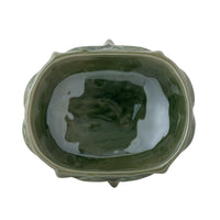 Green ceramic bowl with a textured surface on a white background