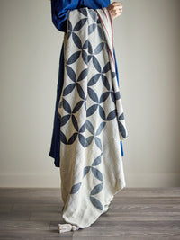Forma throw draped over a model showing geometric print and striped edge