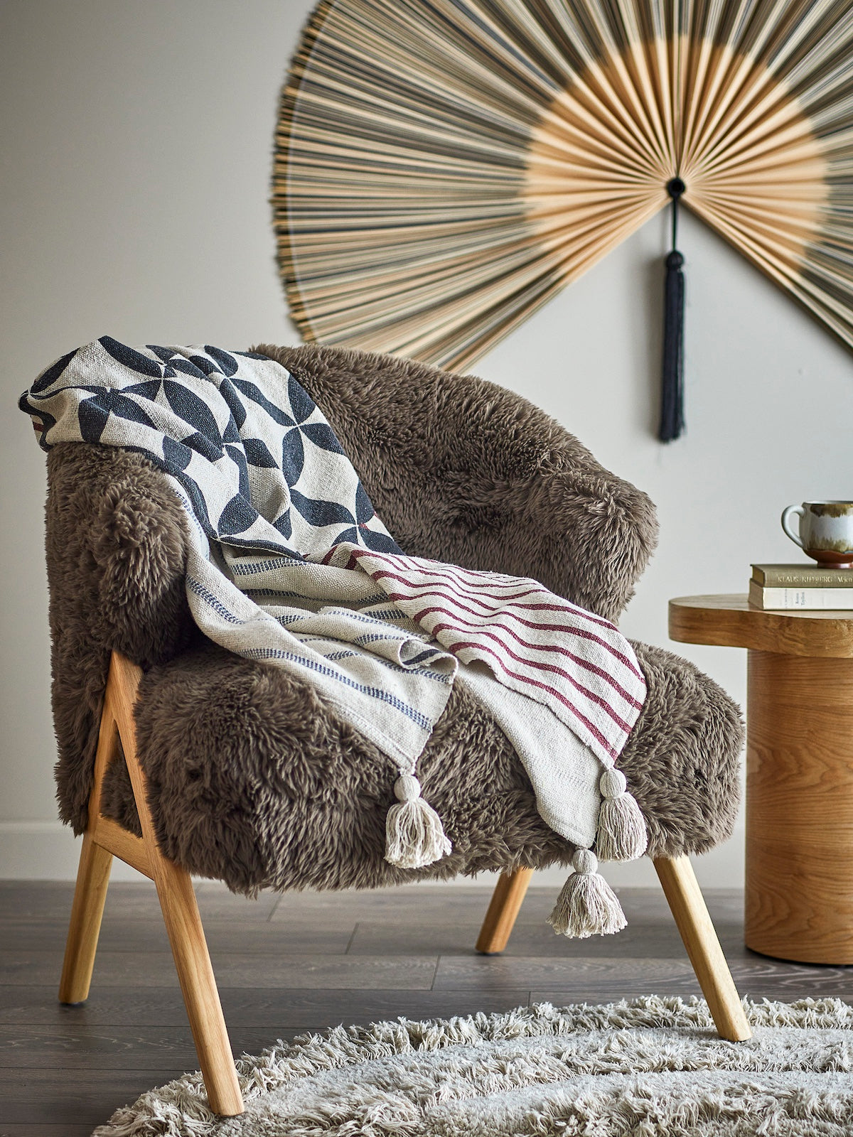 Forma neutral throw with geometric print draped over a shaggy brown armchair
