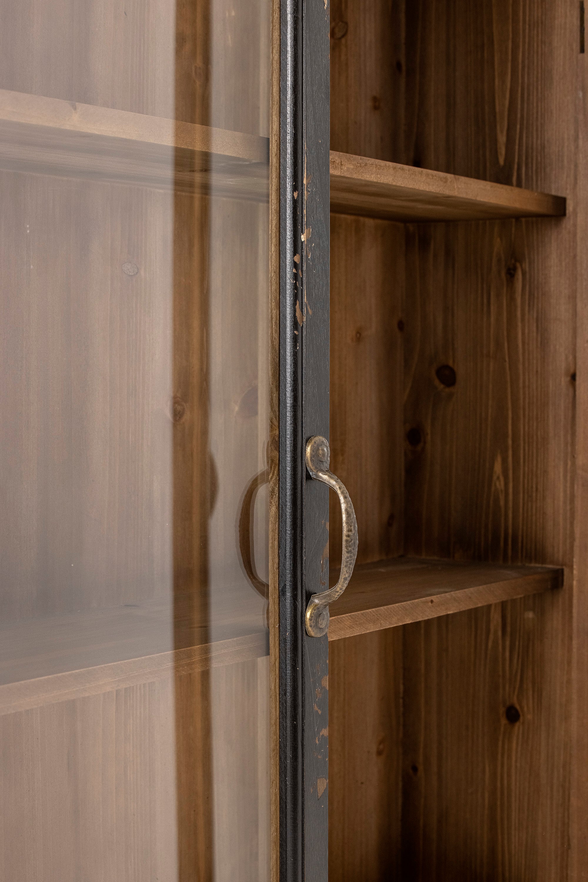 Close-up of the Hazem cabinet's top corner, showing the distressed black paintwork and the wall safety strap fitting
