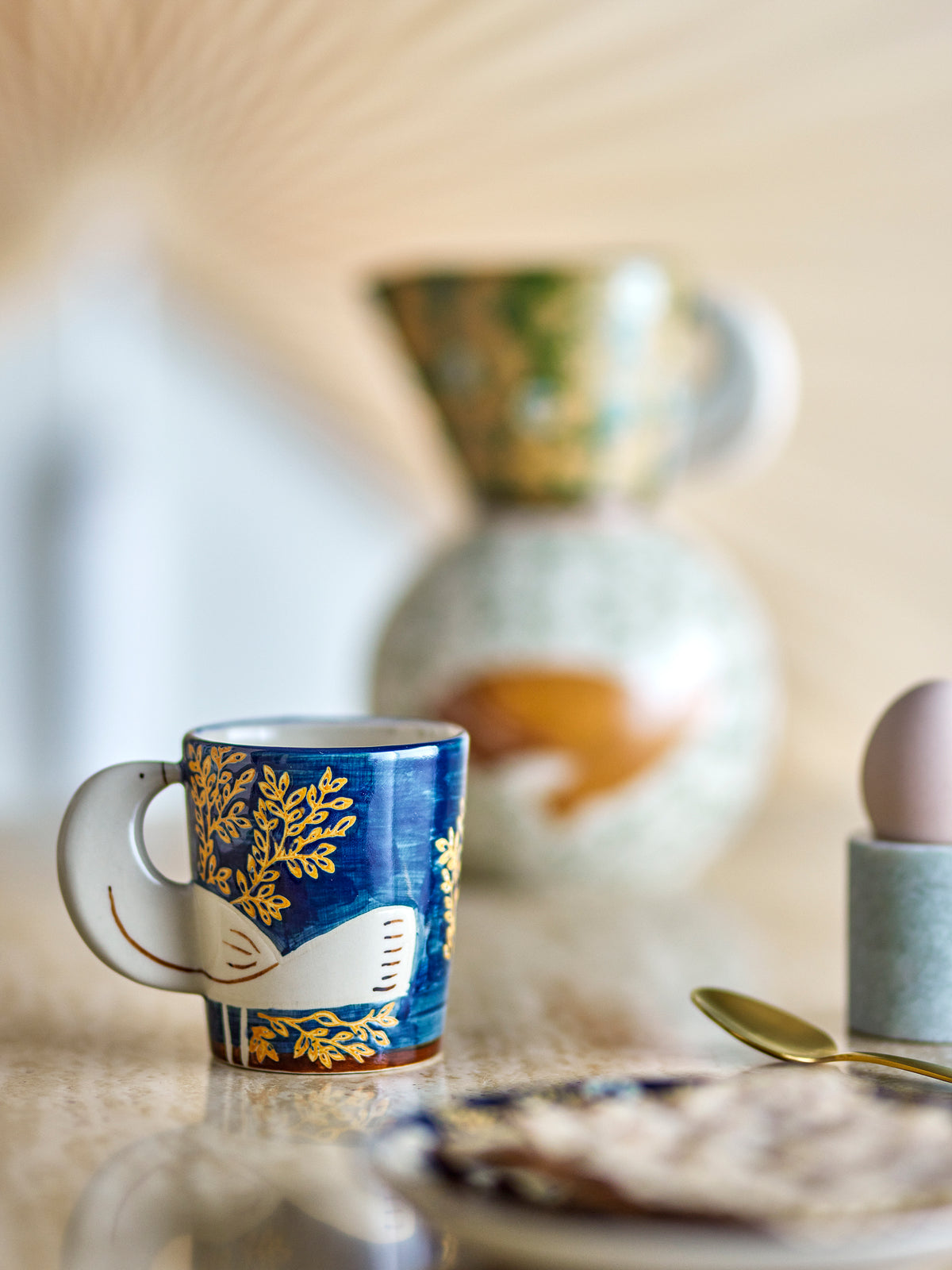 Bloomingville Hezha Nature cup displayed on a breakfast table with soft-focus ceramics in the background.