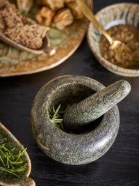 Arazo mortar and pestle in green marble, used for crushing herbs on a kitchen table
