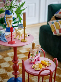 yellow bloomimgville eber candle holder styled on pink side table with colourful ceramics
