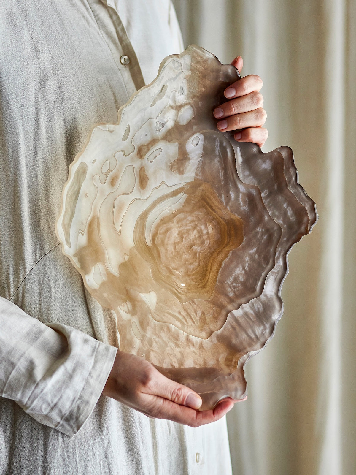Aiku frosted glass bowl held in hands showing full rippled shell shape