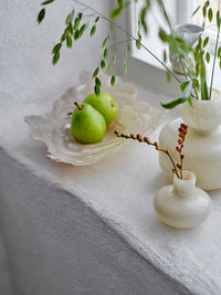 Aiku frosted oyster glass bowl styled on a windowsill with pears and small vases