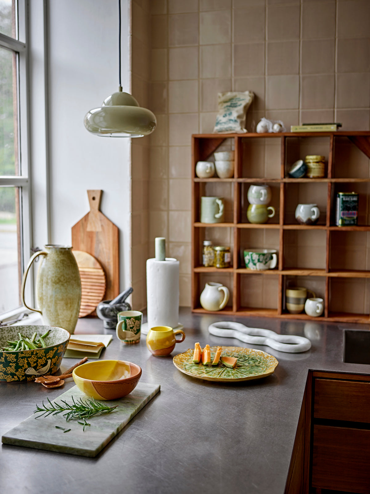Kitchen counter with ceramic items and a wooden shelf in the background