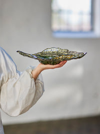 Aiku olive green glass bowl held in hand showing rippled oyster shell shape