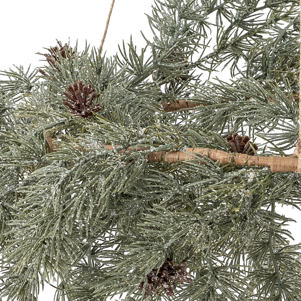 Close-up of the Cedar wreath's frosted green needles, brown pine cones and woven ring