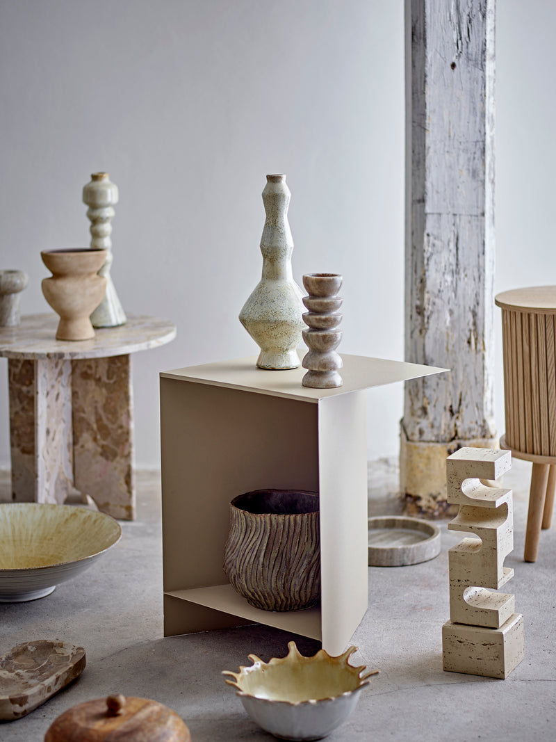 Collection of ceramic and stone sculptures on a neutral background