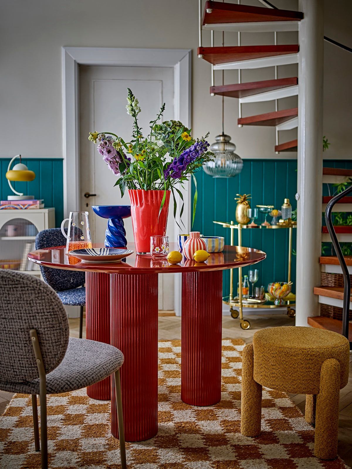 Janine coral red glass vase styled on a red dining table with wildflowers