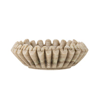 Side view of the Harmonia marble bowl showing its scalloped, ridged edge and shallow base