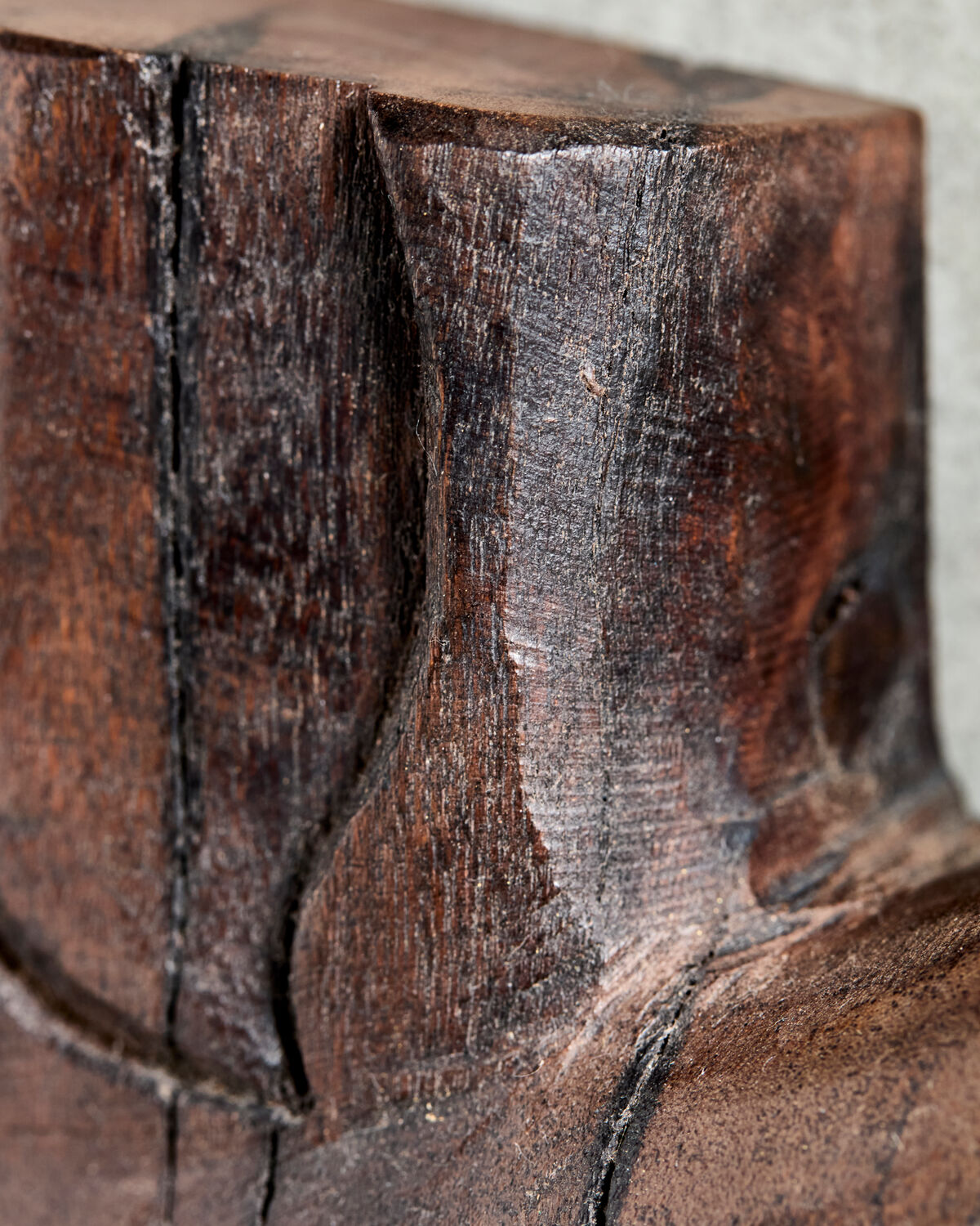 Extreme close-up of the carved mango wood and dark espresso black stain on the House Doctor Human wall art, showing the natural grain and rustic character
