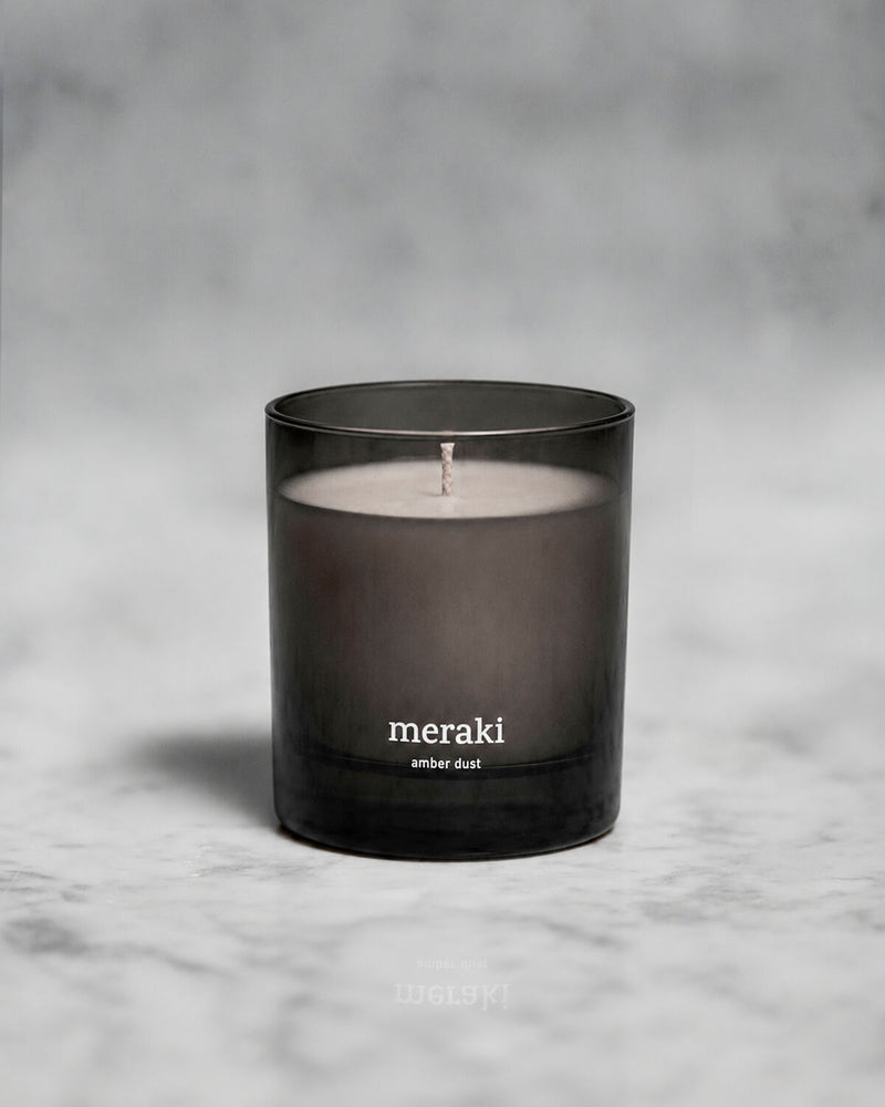 Meraki Amber Dust scented candle styled on a marble surface