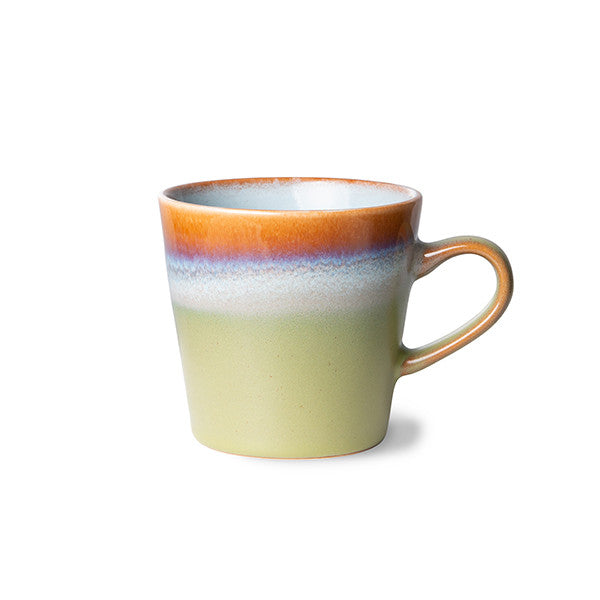 called peat, this handled americano mug has a wide stripe of light green around the bottom, with hints of blue, beige, pink, and purple before the crown of redish orange around the top band